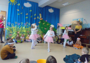 dziewczynki ubrane w różowo-białe stroje tańczą